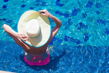 büyük şapka yüzme havuzunda rahatlatıcı genç kadın