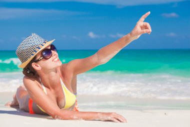 Hasır şapka ve tropikal Plajı'nda giyen bikini uzun saçlı genç kadın