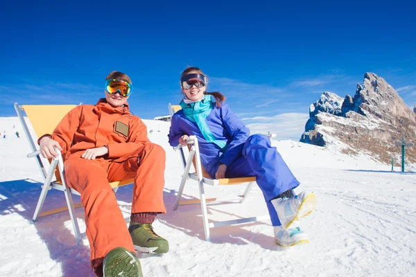 Two snowboarders on top of the mountain having fun sitting on chair chaise lounge — Stock Photo, Image