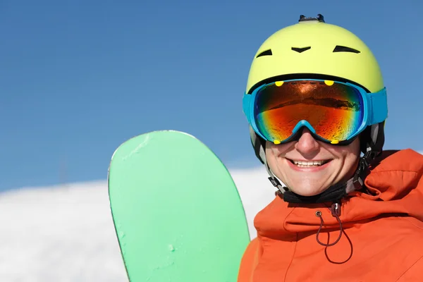 Retrato de un snowboarder sonriendo en la cima de las montañas — Foto de Stock