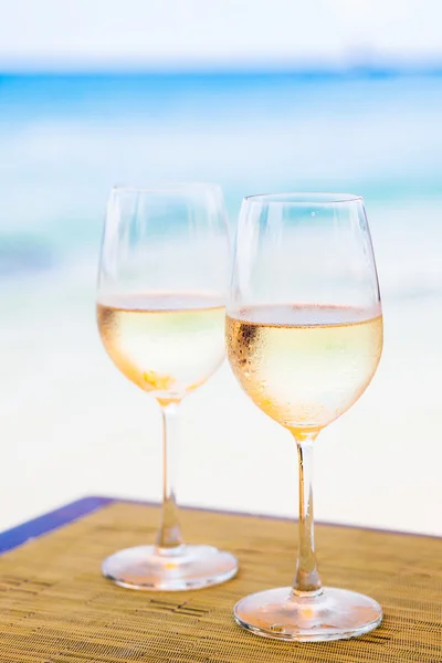 Due bicchieri di vino bianco freddo sul tavolo vicino alla spiaggia — Foto Stock