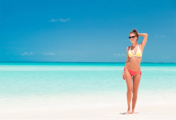 Junges Mädchen im hellen Bikini am tropischen Strand — Stockfoto