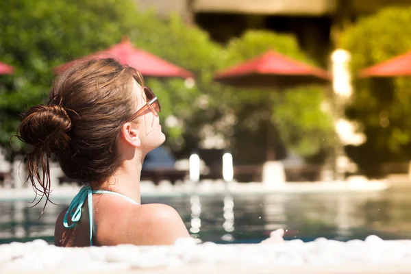 Mooie jonge vrouw in zonnebril in luxe zwembad — Stockfoto