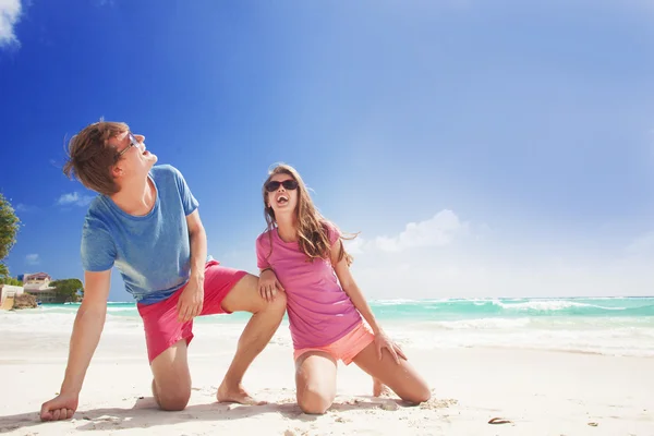 Пара в яркой одежде наслаждаясь солнечным днем на тропическом пляже — стоковое фото