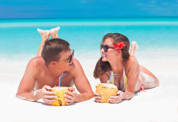 Couple dans des lunettes de soleil avec du jus de coco à la plage tropicale — Photo