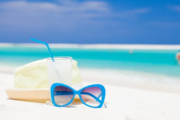 Sunglasses and straw hat on tropical beach — Stock Photo, Image