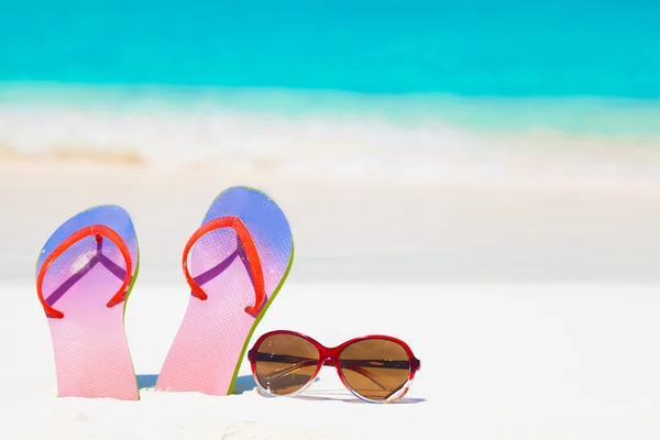 Chanclas brillantes y gafas de sol en un fondo de resort marino tropical —  Fotos de Stock