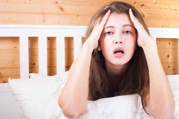 Young long haired woman waking up in the morning at home a with headache — Stock Photo, Image