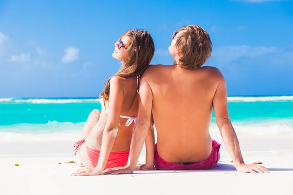 해변에 앉아 행복 한 젊은 백인 커플의 뒷면 — 스톡 사진