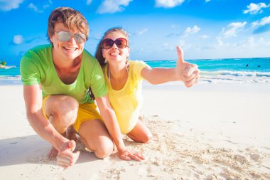 Kumsalda gülümseyen güneş gözlüğü mutlu genç beyaz çiftin yakın çekim