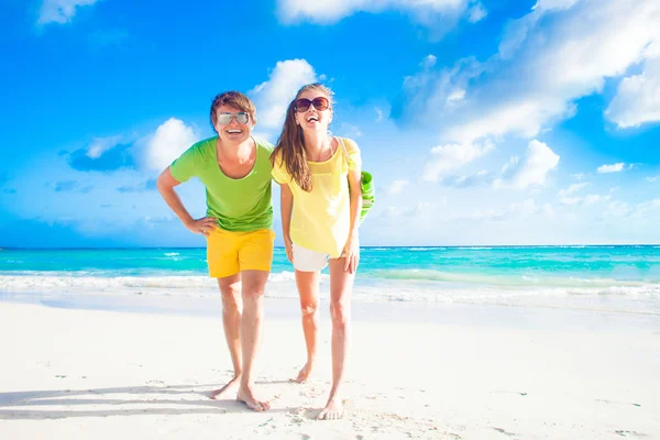 Feliz jovem casal caucasiano em óculos de sol sorrindo na praia — Fotografia de Stock