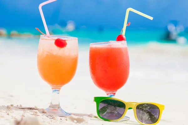 Exotische Cocktails und Sonnenbrillen, karibischer Strand im Hintergrund — Stockfoto