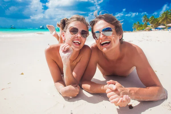 Close up van gelukkige jonge Kaukasische paar in zonnebril glimlachend op strand — Stockfoto