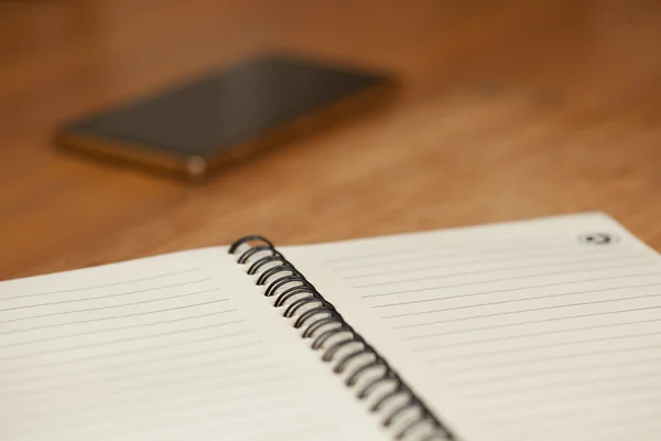 Notepad with spring on a wooden table — Stock Photo, Image