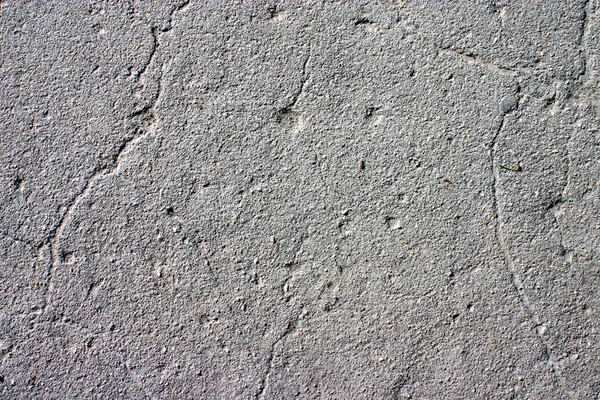 Grey asphalt, covered with cracks — Stock Photo, Image