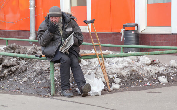white homeless in Russia, in Moscow on March 28, reading a newspaper