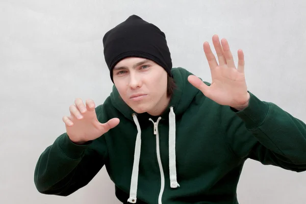 Un joven blanco con una túnica verde y una gorra negra de punto — Foto de Stock