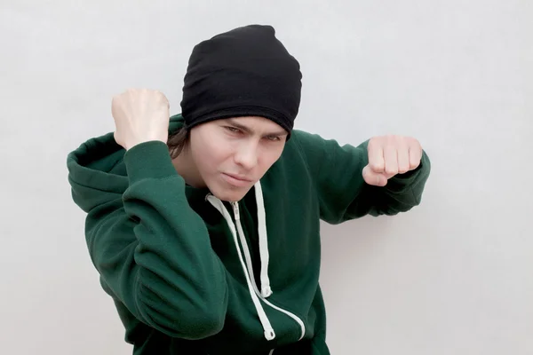 Белый молодой человек в зеленом халате и черной вязаной шапке — стоковое фото