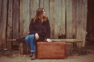 Bir bavul eski çit zemin karşı bankta kızla