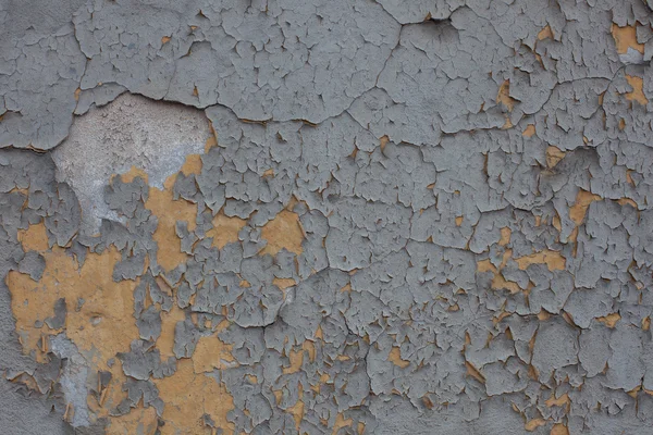 Pintura gris y agrietada en la pared amarilla —  Fotos de Stock