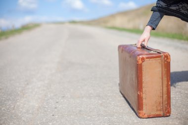 ıssız bir yolda eski kahverengi bavul standları