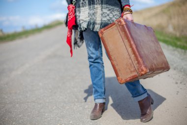 ıssız bir yolda eski kahverengi bavul standları