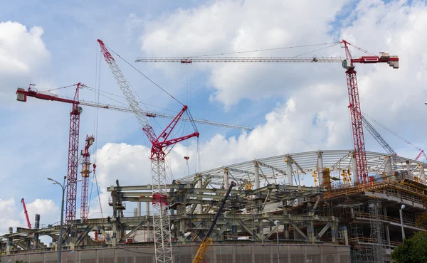 Grúas de construcción sobre un fondo de cielo azul con nubes — Foto de Stock