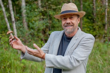 şapkalı bir adam elinde bir mantar ile