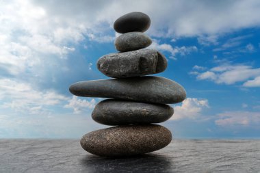 Dengesiz durumdaki çakıl yığını. Düz taşlardan yapılmış bir piramit. 