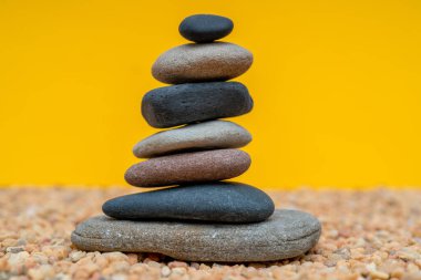 Dengesiz durumdaki çakıl yığını. Düz taşlardan yapılmış bir piramit. 