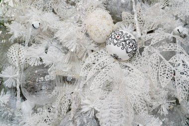 Beyaz karla kaplı ağaç oyuncaklarla süslenmiş..