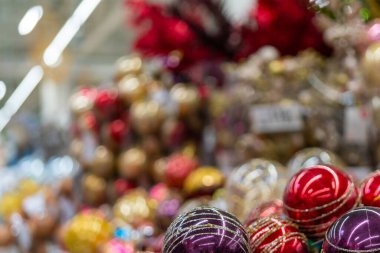 Bulanık Noel süpermarketi. Perakende mağazasında Noel aksesuarları ve ağaçlar satılıyor. Mağazanın arka planı bulanık. Seçici odak.