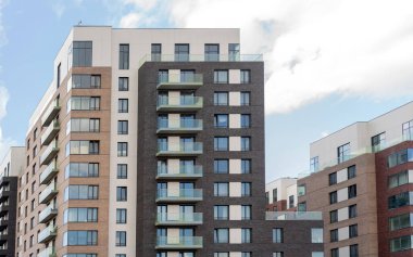 Modern bir binada, balkonlu daireler. İnşaat, kiralama ve konut satışı. 