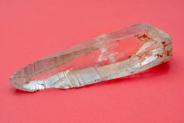 Горный кварцевый кристалл на розовом фоне. Объект минералогии. 