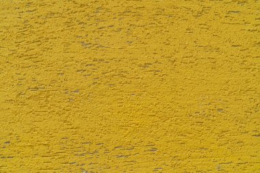 Bir binanın sarı alçı duvarı. Sert yüzey dokusu. 