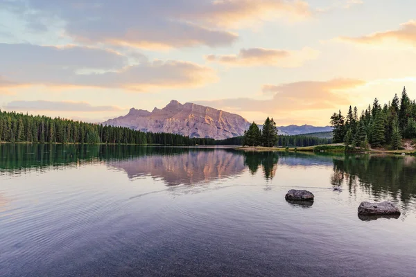 Kaksi Jack Lakea auringonlaskun aikaan, Banffin kansallispuisto, Kanada. Auringonlasku ja pohdinta — kuvapankkivalokuva