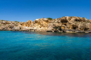 Favignana, Sicilya, İtalya. İnsanlar kayalık uçurumlarda güneşleniyor ve yüzüyorlar..