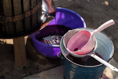 Şarap üreticisi varillere taşınmak için üzüm suyu döker..