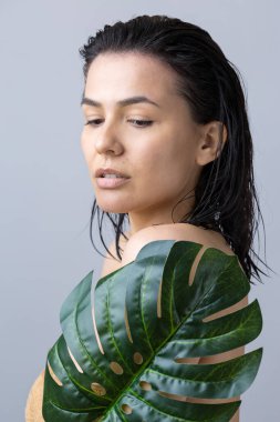 Doğal yeşil palmiye yaprağı portresi olan bir kadın. Moda, güzellik, makyaj, kozmetik.