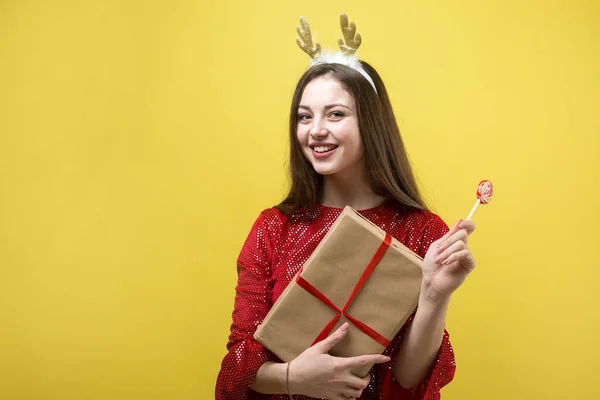 Uma Menina Vestido Vermelho Com Presente Contra Fundo Amarelo — Fotografia de Stock