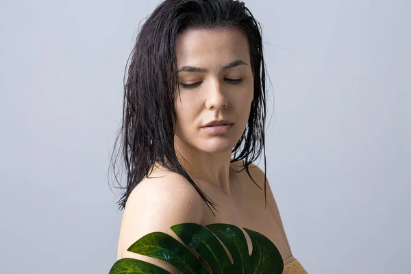 Beauty Woman with natural green palm leaf portrait. Fashion, beauty, make-up, cosmetics.