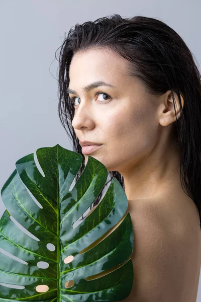 Beauty Woman with natural green palm leaf portrait. Fashion, beauty, make-up, cosmetics.