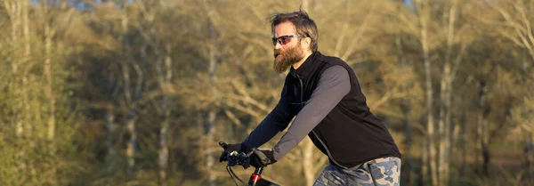現代のマウンテンバイクで残酷な髭の男をスポーツ 春の緑の丘の上のサイクリスト — ストック写真