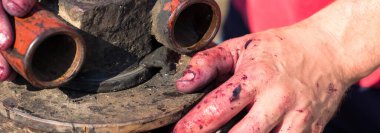 Kırmızılı şarap presi ve sarmal vida. Şarap üreticisinin elleri kapalı..