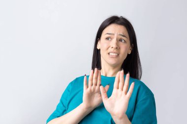 Rahatsız edici güzel esmer portresi, el hareketlerini durdurmak için kaldırıyor. Bu kadar yeter, teşekkürler..