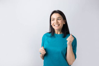 Çekici bağırışların yakın portresi. Genç yaşta yumruklarıyla gülümsüyor. Gri arka planda izole kot gömlek giyen kız arkadaşı.