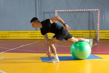 Spor giyimli atletik adam ve spor salonunda spor yapıyor..