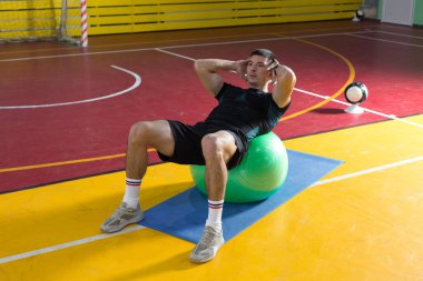 Spor giyimli atletik adam ve spor salonunda spor yapıyor..