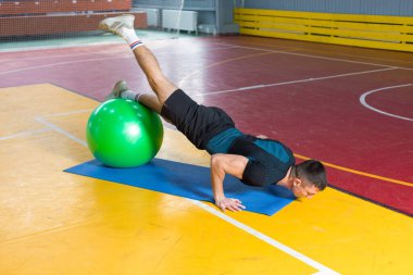 Spor giyimli atletik adam ve spor salonunda spor yapıyor..