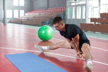 Spor giyimli atletik adam ve spor salonunda spor yapıyor..